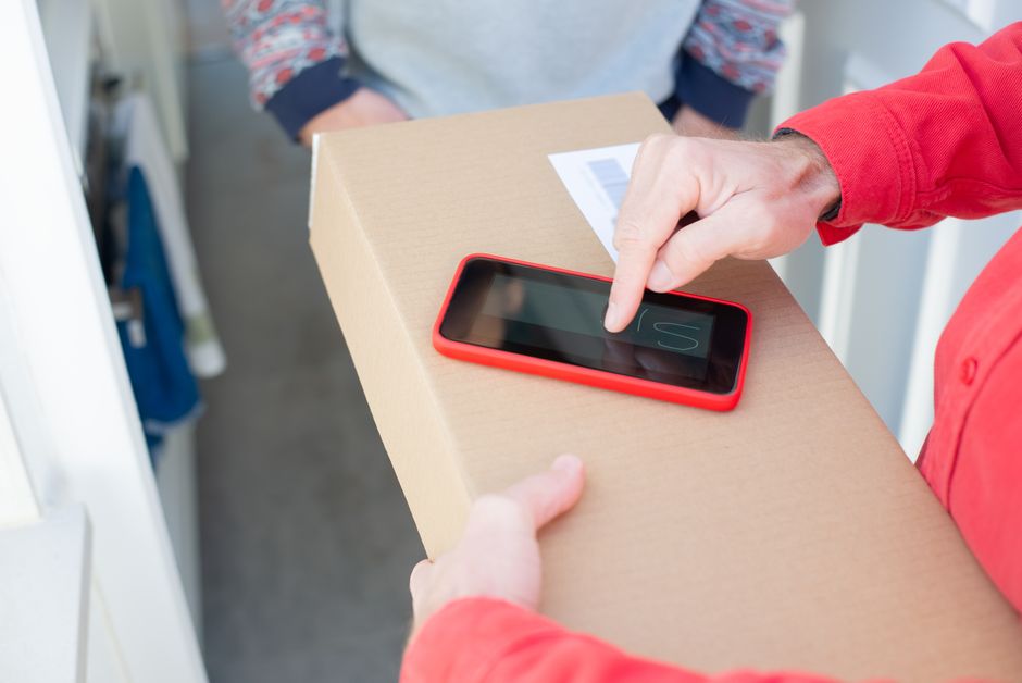 Cartons de livraison empilés devant une porte d'entrée