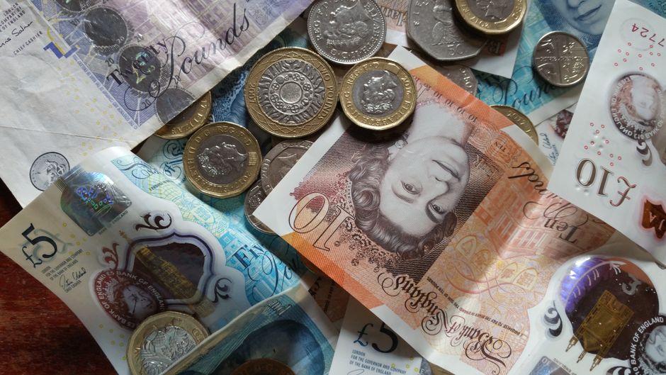 Pièces et billets de livre sterling sur un comptoir